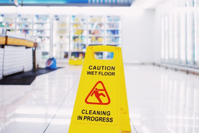 Premises liability lawyer in Bakersfield reviewing a caution wet floor hazard in a store aisle