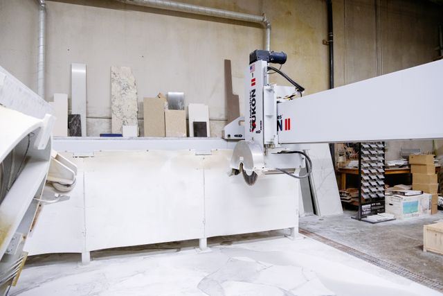 Bridge saw cutting an engineered stone slab in a countertop fabrication shop, the work a silicosis lawyer investigates